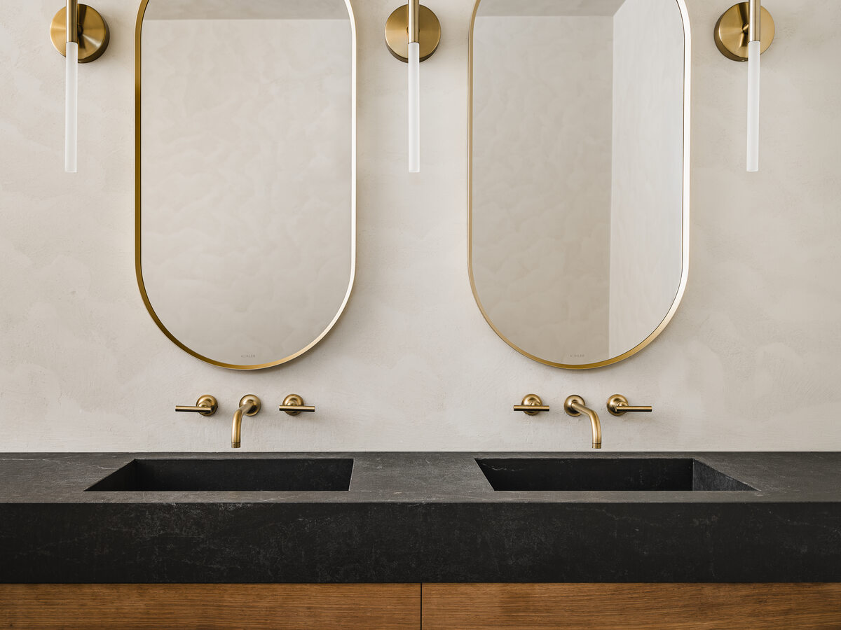 Custom double vanity with brass fixtures and walnut cabinetry